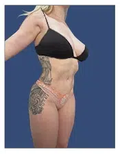 A woman with tattoos wearing a black bikini top and peach bikini bottom.