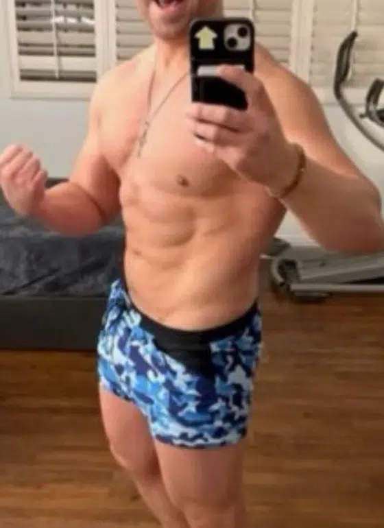 A man in blue shorts taking a selfie, showcasing an insider moment.