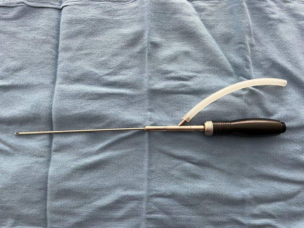 A needle with a tube on a blue cloth for Safe BBL Protocol.